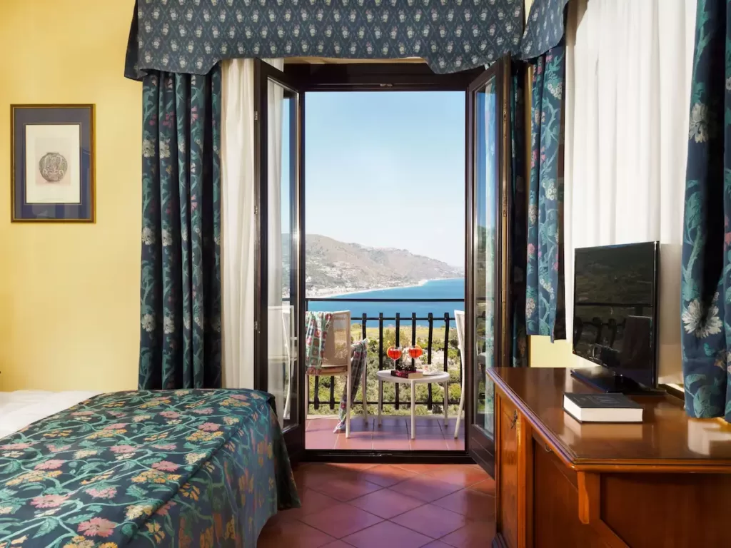 Bedroom with balcony and ocean view at Hotel Sirius Taormina